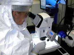 Researcher looking through microscope in lab